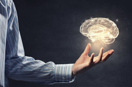 Businessman holding digital image of brain representing artificial intelligence in palm.jpeg